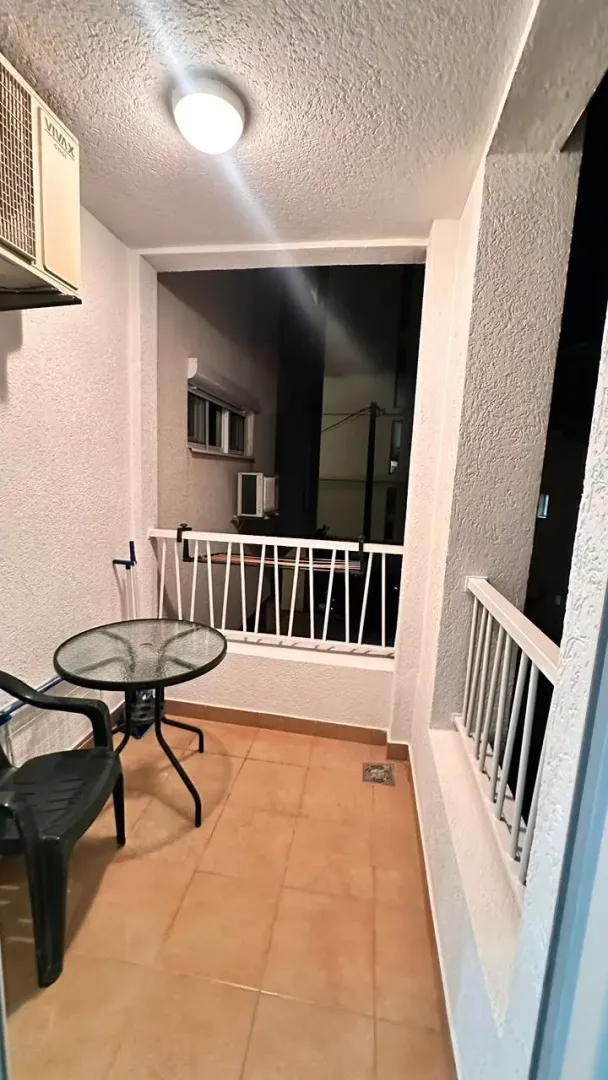 Small covered balcony with seating furniture.