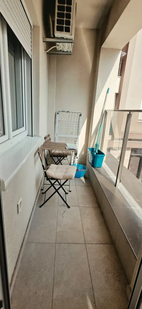 Manja natkrivena terasa sa stolom, stolicama i priborom za čišćenje.