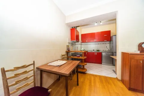 Smaller kitchen with red cabinets and a dining table. - image 4