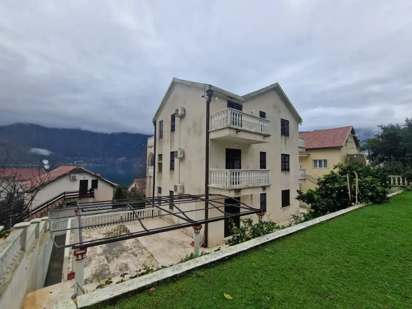 View of the exterior of the house with a courtyard and balcony.