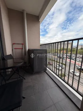 Covered balcony with seating furniture and a city view. - image 14