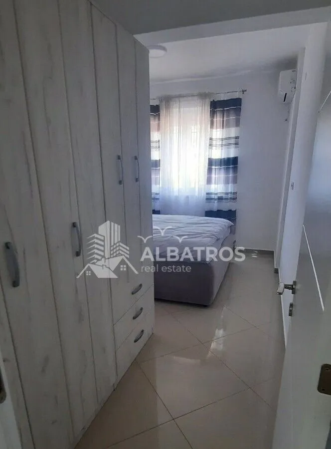 View from the hallway into the bedroom with a wardrobe and a bed.