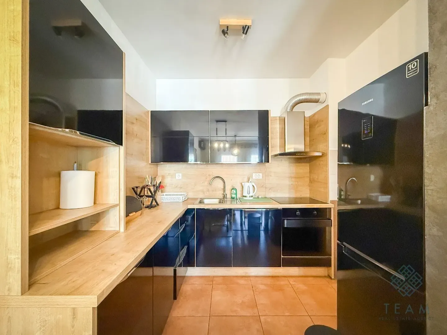 Modern kitchen with dark cabinets and wooden details.