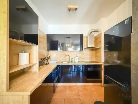 Modern kitchen with dark cabinets and wooden details. - image 4