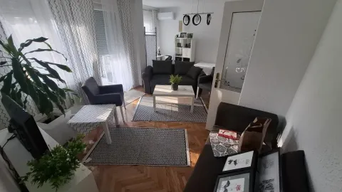 Prostrana dnevna soba sa garniturom za sedenje i parketom. - image 3
