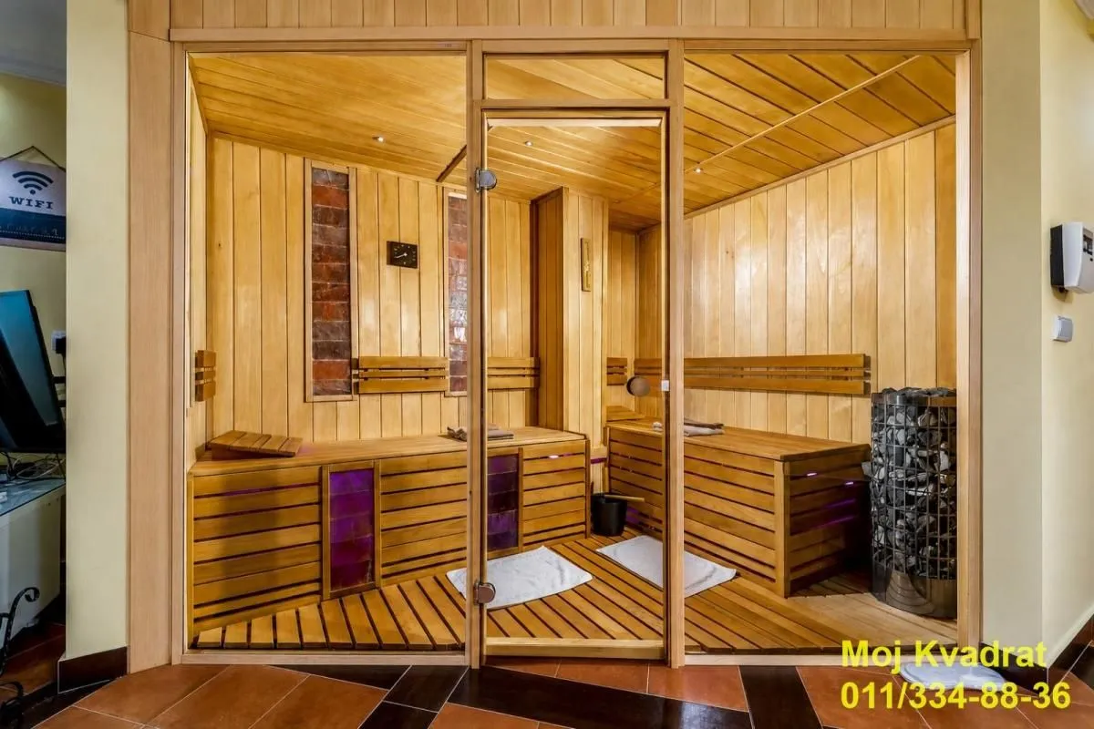 Drvena sauna sa staklenim vratima i klupama.