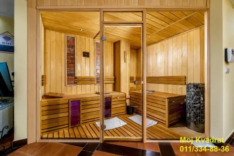 Drvena sauna sa staklenim vratima i klupama. - image 9