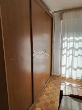 Bedroom with a large wooden wardrobe and parquet flooring. - image 6
