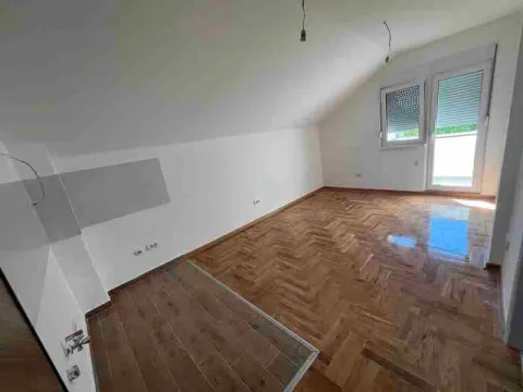 Empty attic room with parquet flooring and balcony doors. - image 5