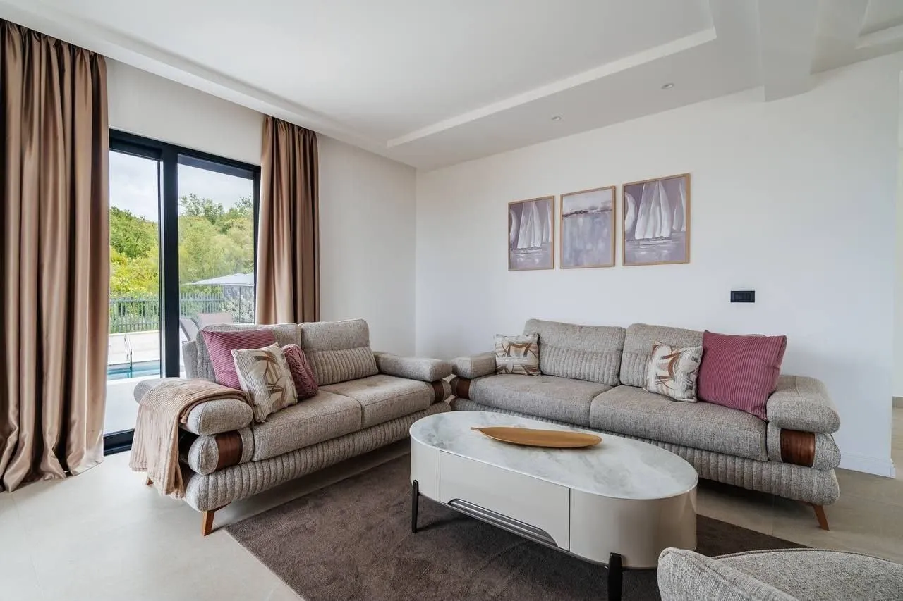 Spacious living room with a sofa set, coffee table, and terrace access.