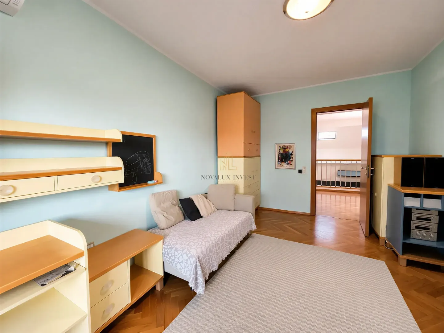 Children's bedroom with a bed, wardrobe, and desk.