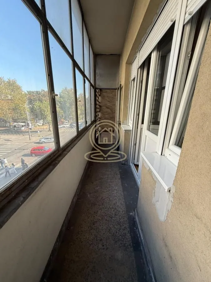 Zastakljeni balkon sa pogledom na ulicu.