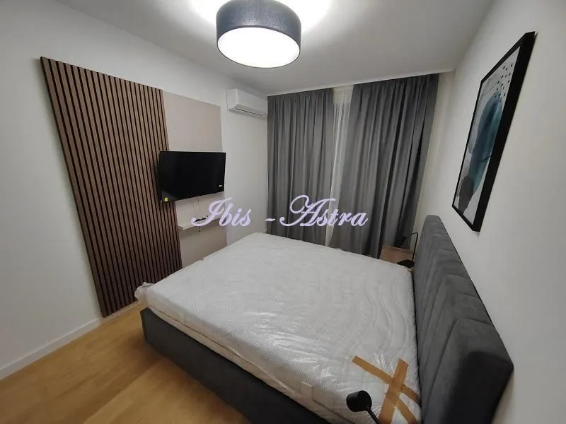Furnished bedroom with a double bed, TV, and air conditioning.