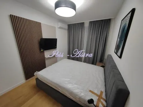 Furnished bedroom with a double bed, TV, and air conditioning. - image 4