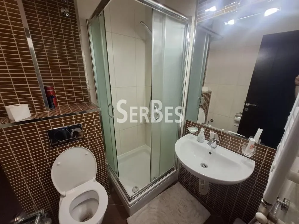 Bathroom with a shower cabin, washbasin, and toilet.