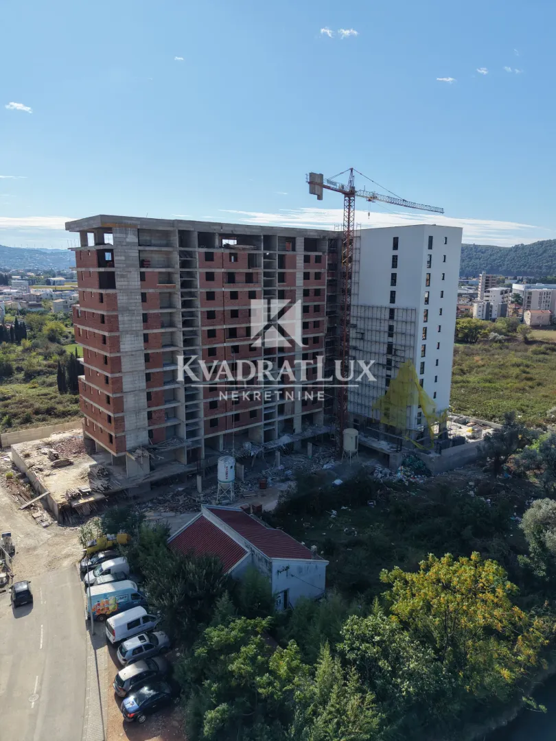 Pogled iz vazduha na stambenu zgradu u izgradnji sa kranom.