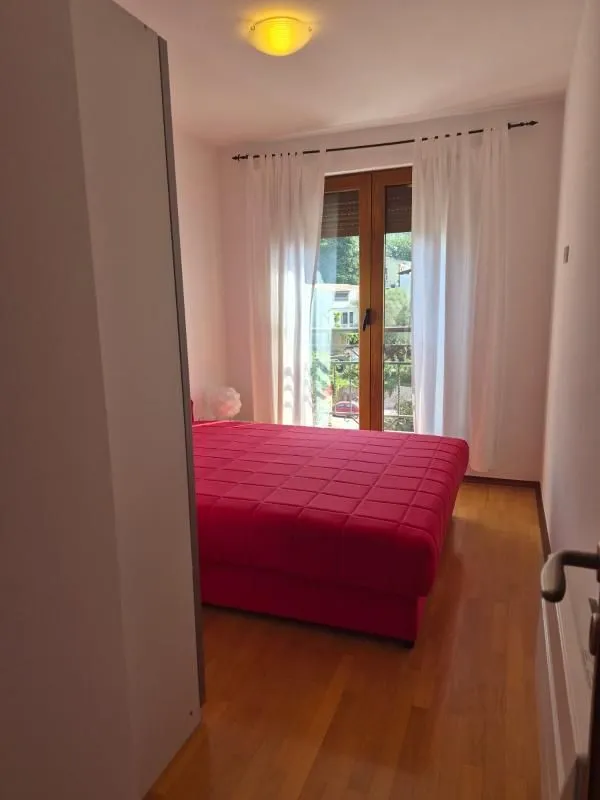 Spavaća soba sa bračnim krevetom i izlazom na terasu.