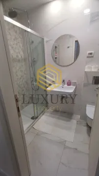 Modern bathroom with a shower cabin, washbasin, and toilet. - image 2