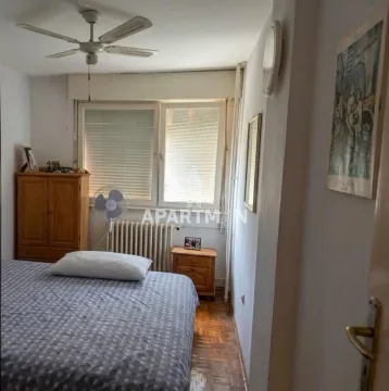Spavaća soba sa krevetom, drvenim ormarom i plafonskim ventilatorom. - image 2