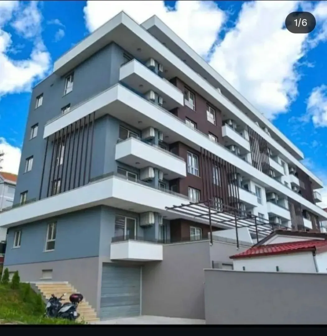 Exterior of a modern multi-family residential building with balconies and a finished facade.