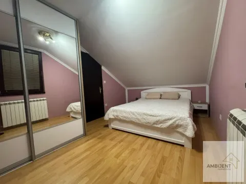 Spavaća soba sa bračnim krevetom, ormarom sa ogledalom i kosim plafonom. - image 8