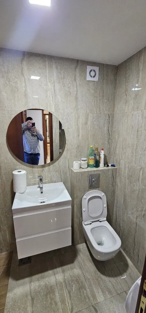 Moderno kupatilo sa lavaboom i ogledalom.