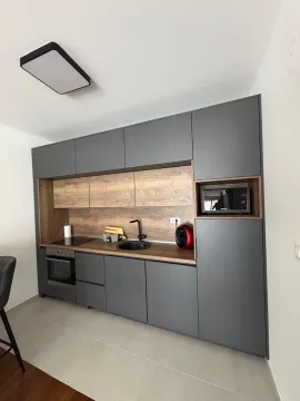Modern kitchen with dark cabinets and wood details. - image 3