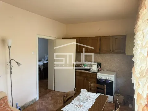 Smaller kitchen with wooden cabinets and a dining table. - image 6