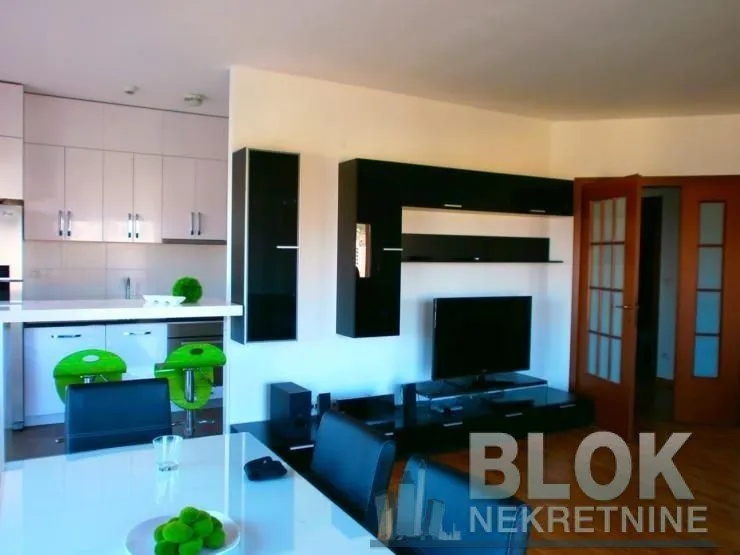 Living room with dining area and open kitchen.