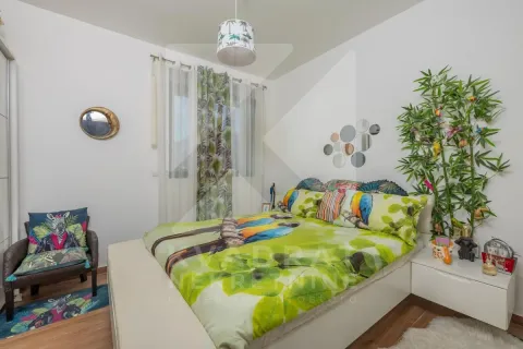 Spavaća soba sa bračnim krevetom i dekorativnim zelenim detaljima. - image 13