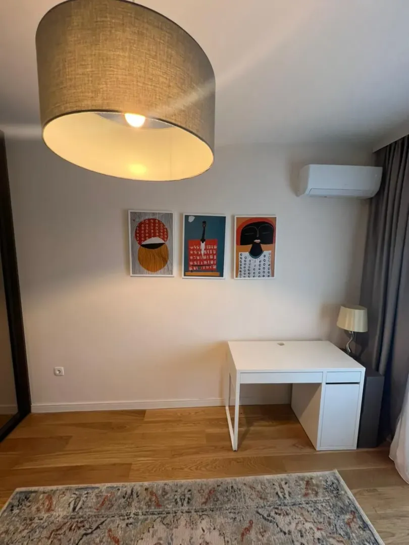 A desk with a chair and artwork on the wall.