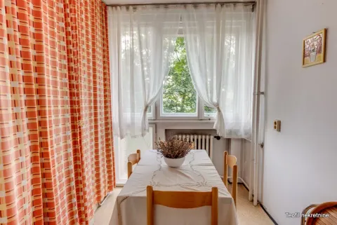 Dining area with a table, chairs, and a window in the background. - image 12