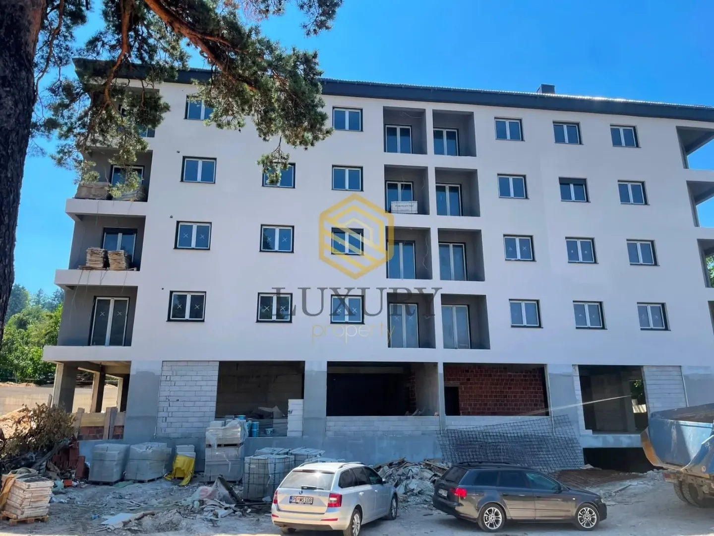 Pogled na spoljašnjost stambene zgrade u izgradnji sa vodenim žigom agencije.