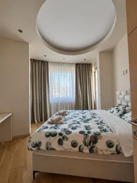 Namještena spavaća soba sa bračnim krevetom i kružnim plafonskim elementom. - image 5