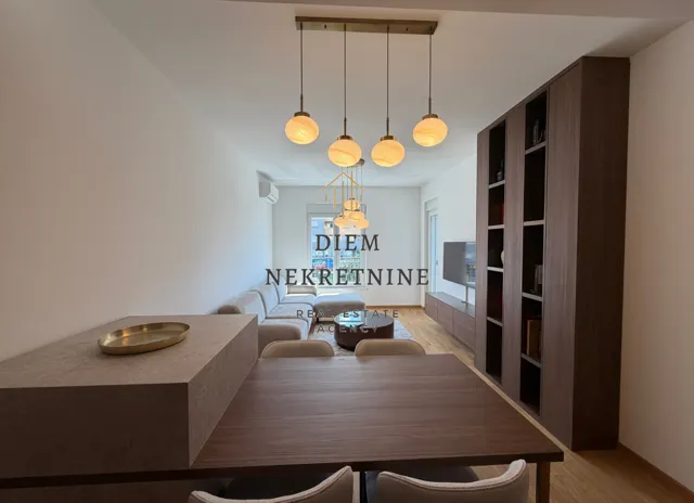 Living room with dining area and modern lighting.