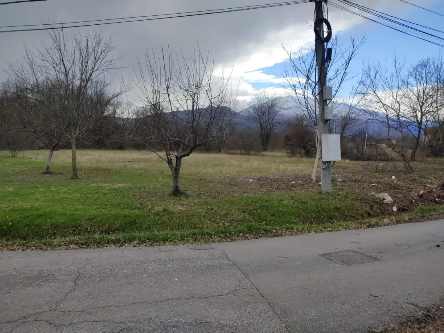 Pogled na plac sa stablima i putem u prvom planu.