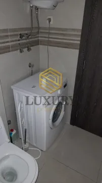 Bathroom with a washing machine and toilet. - image 6