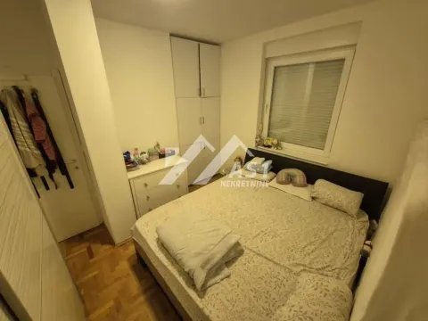 Nameštena spavaća soba sa bračnim krevetom, ormarom i prozorom. - image 7