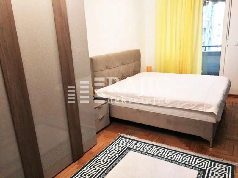 Furnished bedroom with a double bed, wardrobe, and a rug.