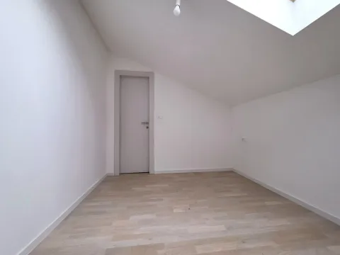 Prazna potkrovna soba sa bijelim zidovima i drvenim podom. - image 10