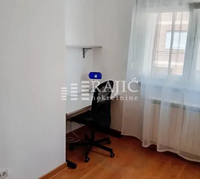 Small room with a desk and a window with white curtains. - image 9