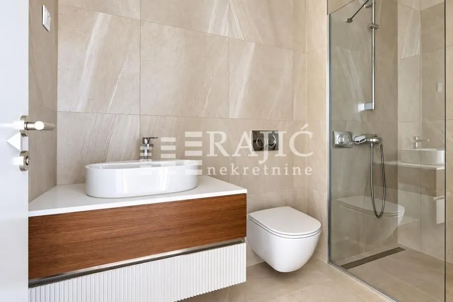 Modern bathroom with a walk-in shower and a sink.