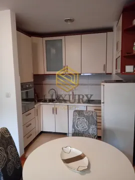 Kitchen equipped with white cabinets and a dining table. - image 6