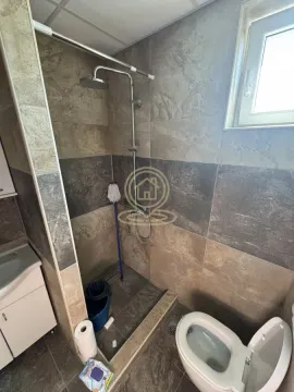 Manje kupatilo sa tuš kabinom i keramičkim pločicama u tamnim tonovima. - image 13