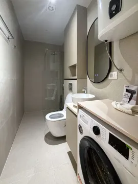 Moderno opremljeno kupatilo sa tuš kabinom, umivaonikom i veš mašinom. - image 11