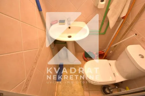 Small bathroom with a sink and toilet tiled with ceramic tiles. - image 8