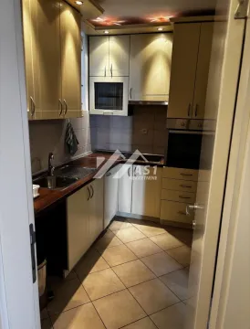 View of a smaller kitchen with wooden cabinets and ceramic floor tiles. - image 4