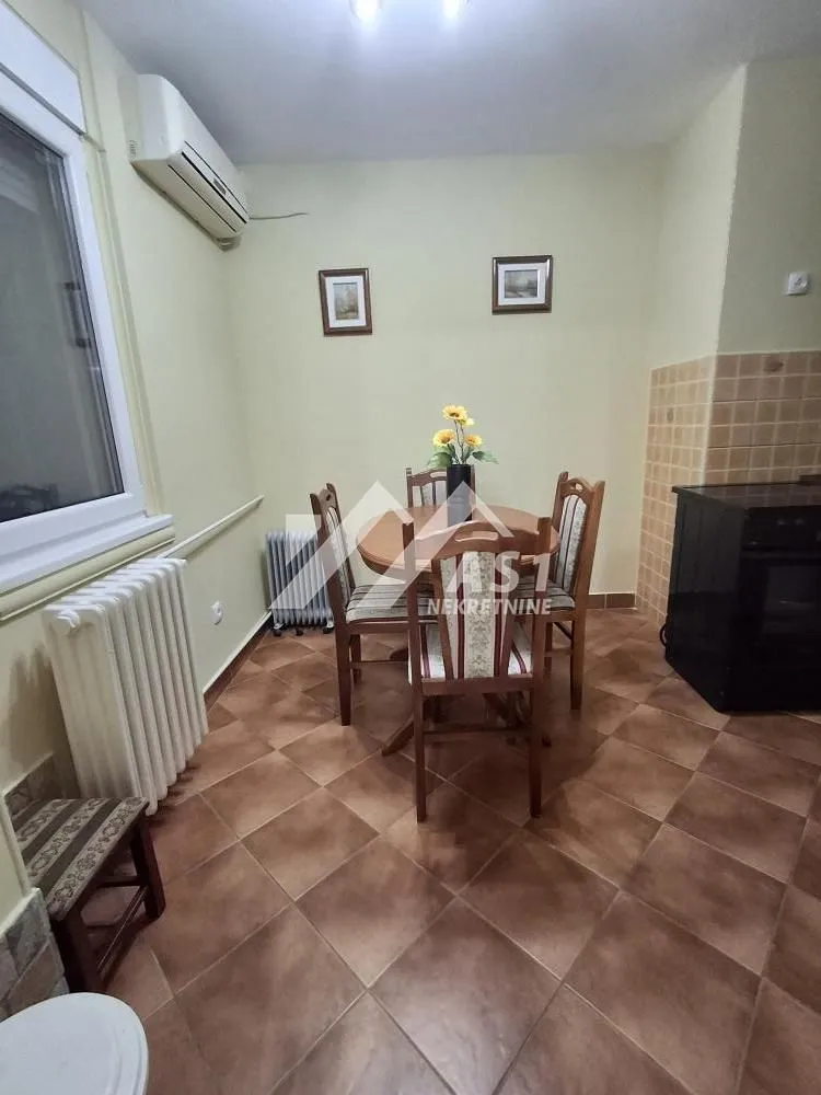 Trpezarijski sto sa stolicama u kuhinji.