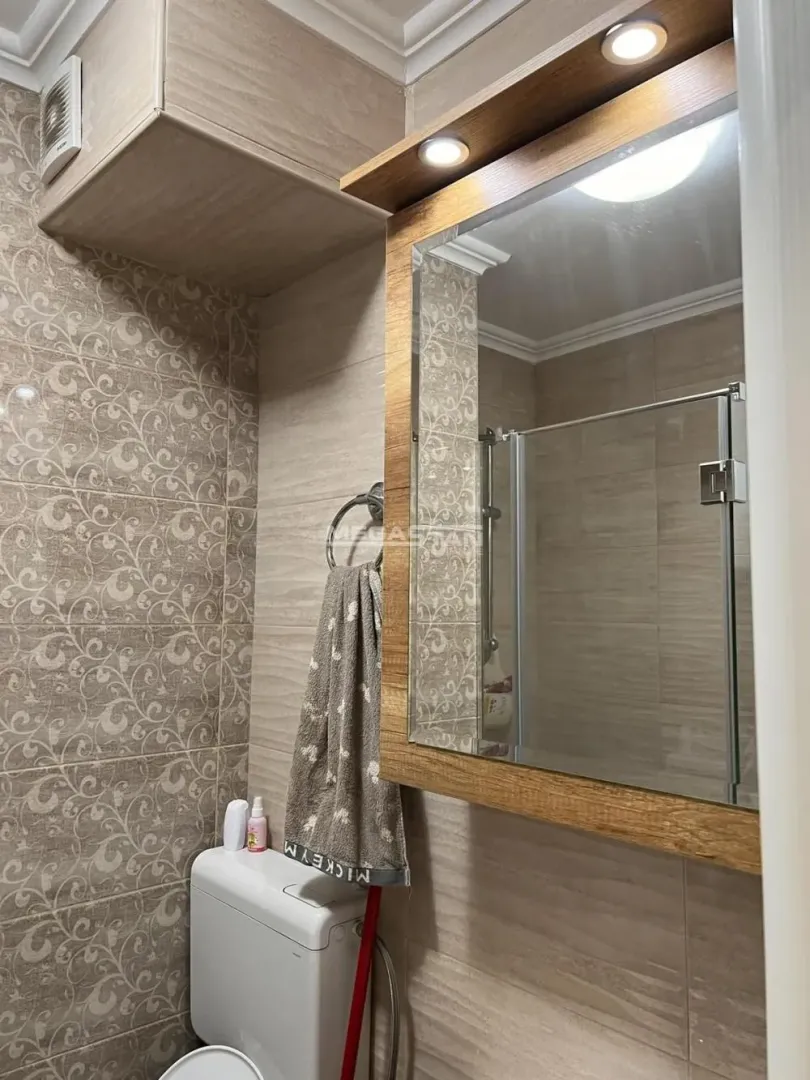 View of the bathroom with a sink, mirror, and toilet.