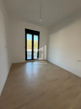 Prazna soba sa drvenim podom i balkonskim vratima. - image 3
